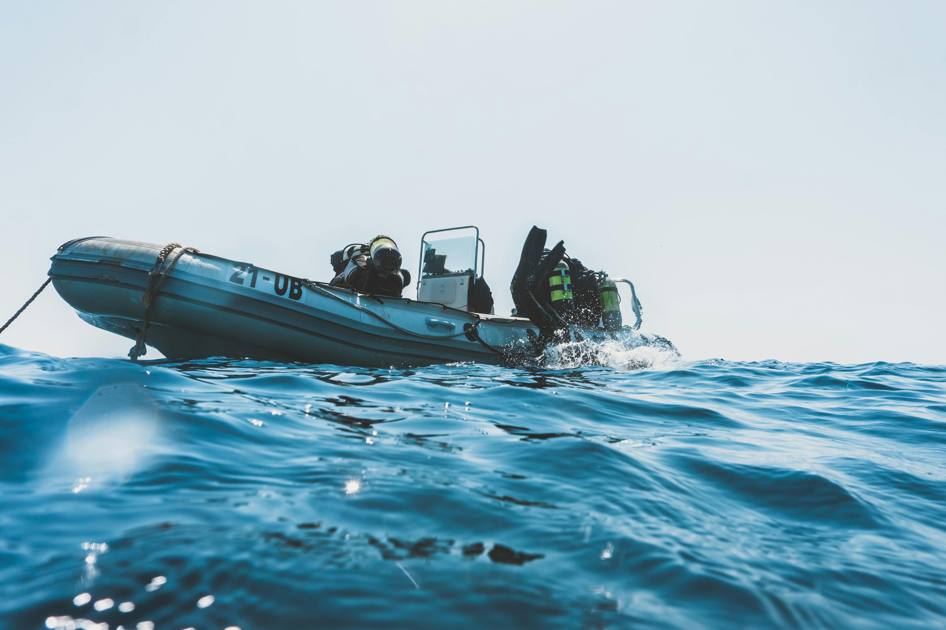 A rigid inflatable boat (RIB) with professional divers and their gear on calm blue water, serving as a background for newsletter signup to receive sourcing insights and product updates.